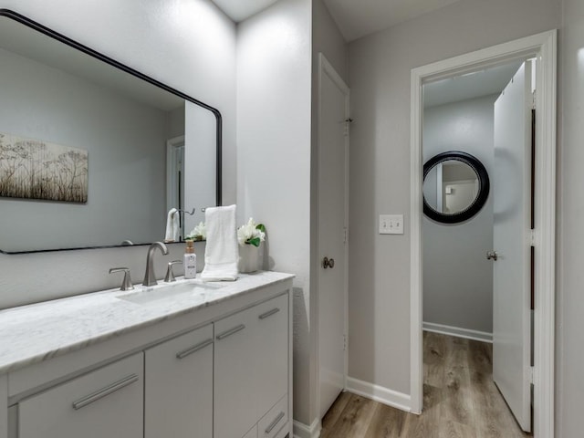 17607 Seedling Ct, Dallas, TX 75287 - bathroom featuring wood finished floors, baseboards, and vanity