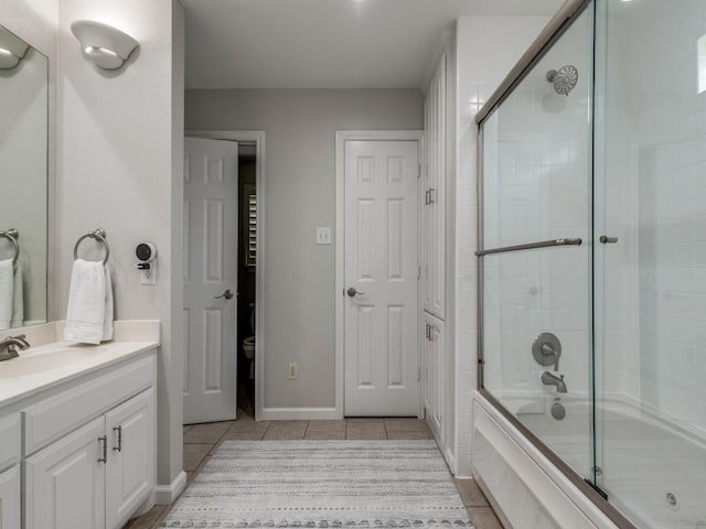17607 Seedling Ct, Dallas, TX 75287 - full bath with tile patterned floors, shower / bath combination with glass door, vanity, and toilet