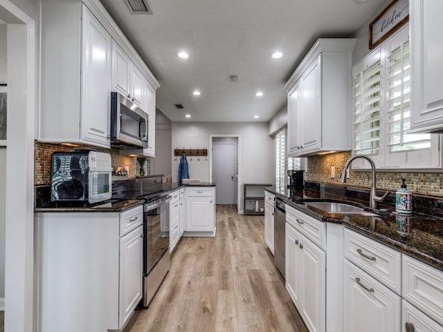 17607 Seedling Ct, Dallas, TX 75287 - kitchen with stainless steel appliances, a sink, light wood-type flooring, white cabinets, and recessed lighting