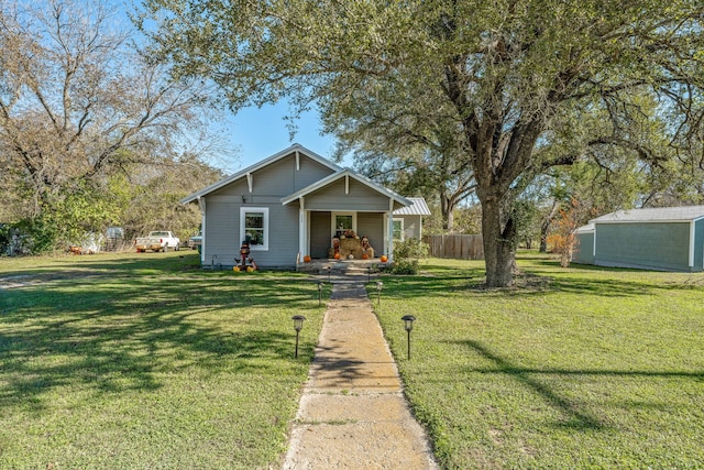 bungalow-style home with a front lawn, a porch, and fence