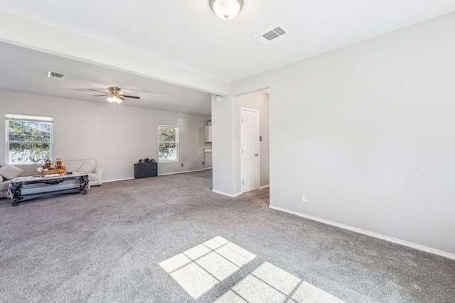 unfurnished living room with baseboards, ceiling fan, visible vents, and carpet floors