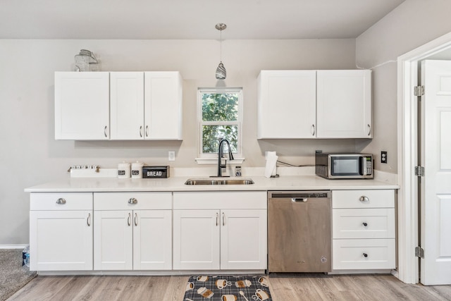 kitchen with white cabinetry, light countertops, appliances with stainless steel finishes, and a sink