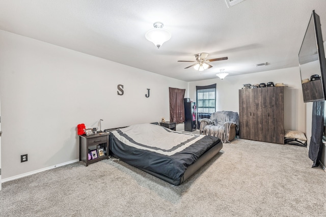 carpeted bedroom with visible vents, baseboards, and ceiling fan
