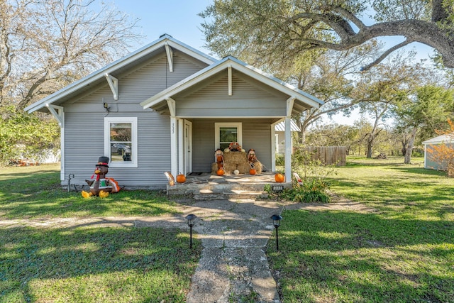bungalow-style house featuring covered porch and a front lawn