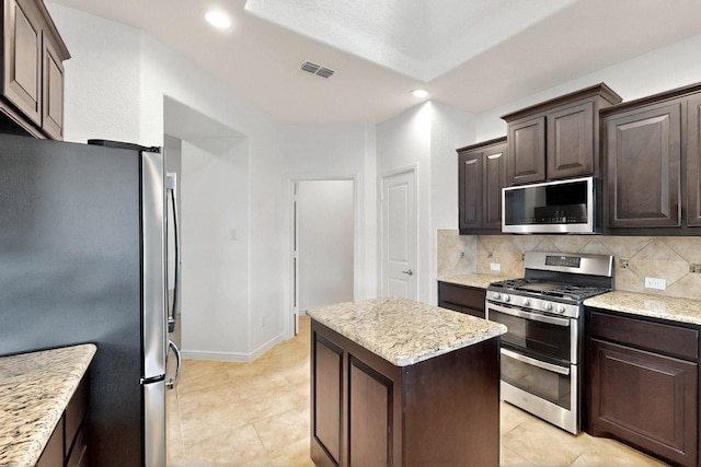 9133 Copper Crossing Dr, Fort Worth, TX 76131 - kitchen with stainless steel appliances, dark brown cabinetry, decorative backsplash, a center island, and recessed lighting