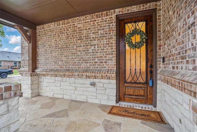 doorway to property featuring brick siding