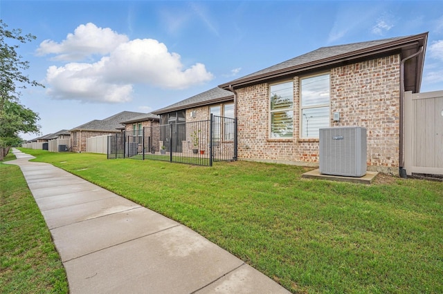 view of yard with fence and central AC