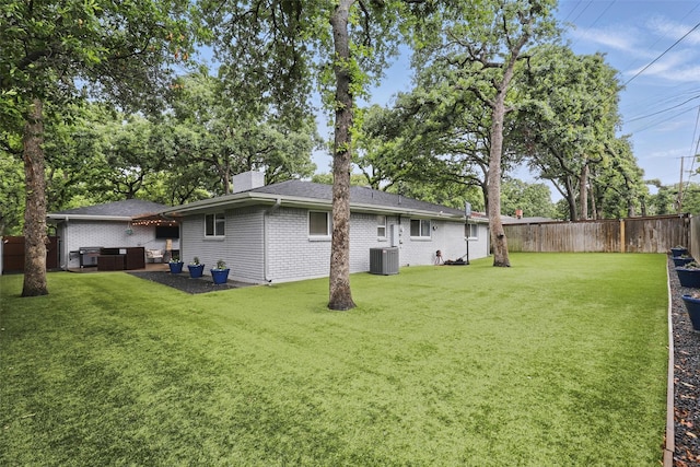 824 Wheelwood Dr, Hurst, TX 76053 - rear view of house with a lawn, a chimney, brick siding, a jacuzzi, and a fenced backyard