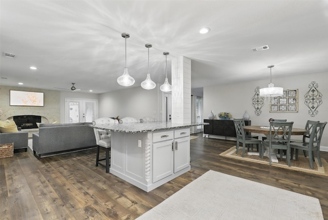 824 Wheelwood Dr, Hurst, TX 76053 - kitchen featuring visible vents, a fireplace, open floor plan, and dark wood-type flooring