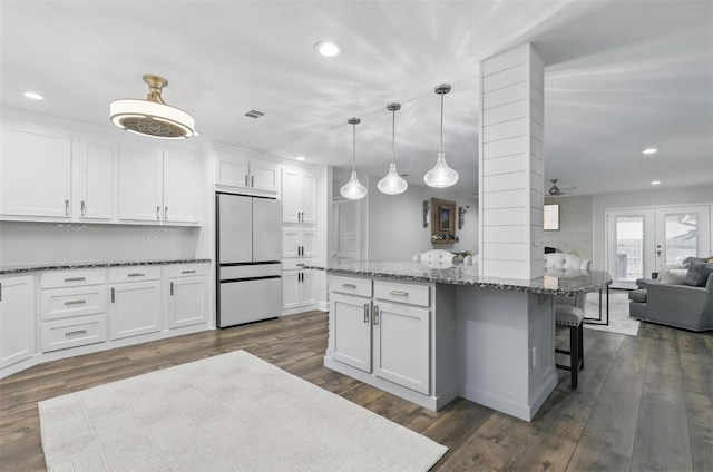 824 Wheelwood Dr, Hurst, TX 76053 - kitchen featuring recessed lighting, white cabinetry, refrigerator, and a breakfast bar
