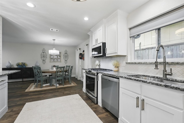 824 Wheelwood Dr, Hurst, TX 76053 - kitchen with a sink, dark stone countertops, visible vents, backsplash, and appliances with stainless steel finishes