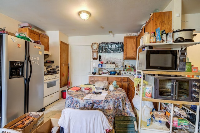 307 W Front St, Sunset, TX 76270 - kitchen with brown cabinets, stainless steel fridge with ice dispenser, light countertops, and white gas stove