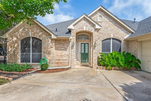 6712 Bluffview Dr, Fort Worth, TX 76132 - doorway to property with brick siding, a shingled roof, and a garage