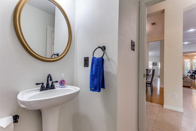 6712 Bluffview Dr, Fort Worth, TX 76132 - bathroom featuring tile patterned floors, a sink, baseboards, and a textured wall
