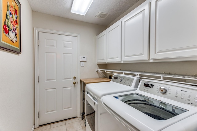 6712 Bluffview Dr, Fort Worth, TX 76132 - laundry room with cabinet space, washing machine and dryer, light tile patterned floors, and a textured ceiling