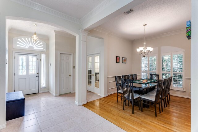 6712 Bluffview Dr, Fort Worth, TX 76132 - dining area with a chandelier, crown molding, plenty of natural light, arched walkways, and french doors