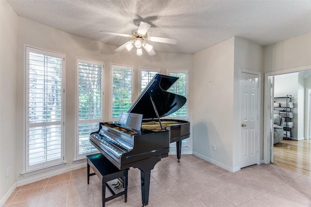 6712 Bluffview Dr, Fort Worth, TX 76132 - living area featuring a ceiling fan, a textured ceiling, baseboards, and light tile patterned flooring