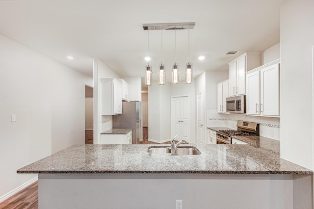 4605 Ashmark Rd, Little Elm, TX 76227 - kitchen featuring a sink, a peninsula, dark stone countertops, backsplash, and stainless steel appliances