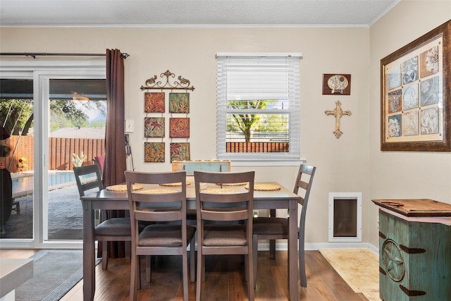 dining space with crown molding, a wealth of natural light, baseboards, and wood finished floors