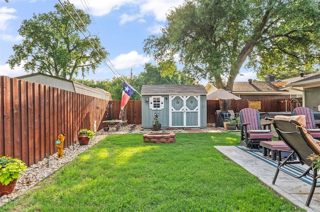 view of yard featuring an outdoor structure, a fire pit, a patio, a shed, and a fenced backyard