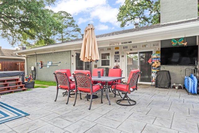 view of patio / terrace featuring outdoor dining area and a hot tub