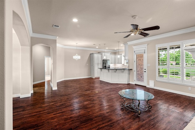5807 Pebble Beach Dr, Granbury, TX 76049 - unfurnished living room with dark wood finished floors, arched walkways, baseboards, crown molding, and recessed lighting