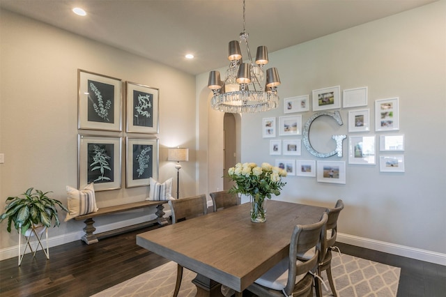 dining room with a notable chandelier, recessed lighting, baseboards, hardwood / wood-style flooring, and arched walkways