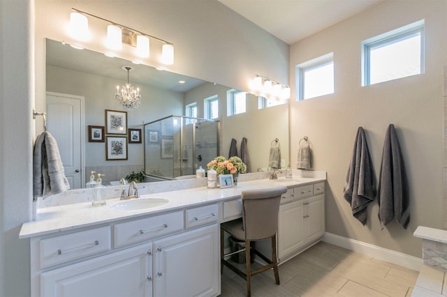 full bathroom with a sink, double vanity, a stall shower, and an inviting chandelier