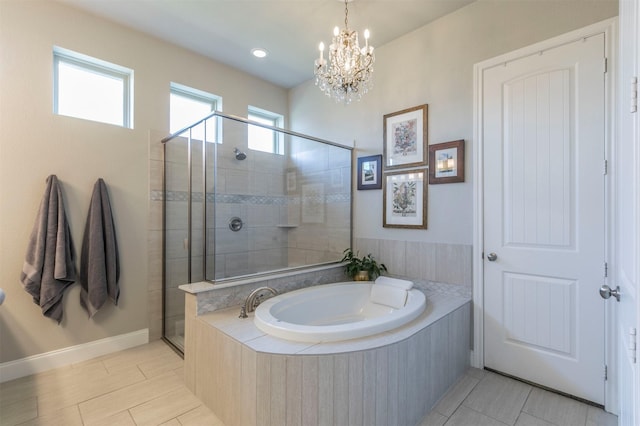 full bath featuring tile patterned floors, an inviting chandelier, a shower stall, baseboards, and a bath
