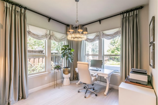 office area with baseboards, a chandelier, and plenty of natural light