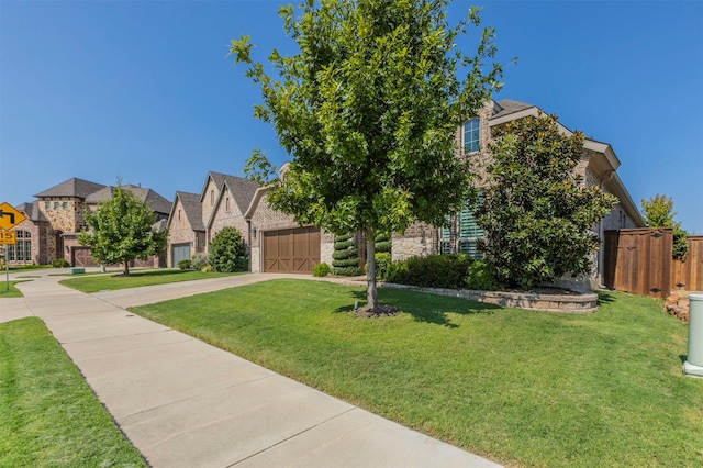 view of front of home featuring concrete driveway, a front lawn, stone siding, and a residential view
