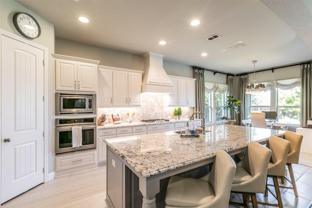 kitchen featuring a sink, stainless steel appliances, custom range hood, and recessed lighting