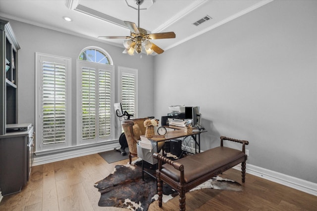 office space featuring ceiling fan, ornamental molding, visible vents, and wood finished floors
