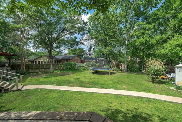 view of yard with a fenced backyard and a trampoline