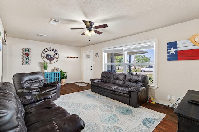 living area with visible vents, baseboards, a ceiling fan, and dark wood-style floors