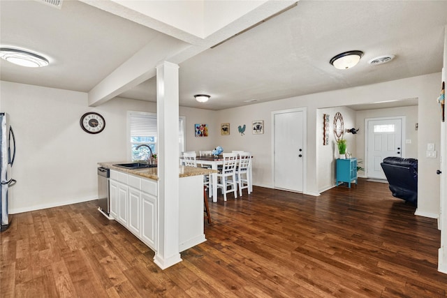 kitchen featuring a sink, stainless steel appliances, dark wood-style floors, and visible vents