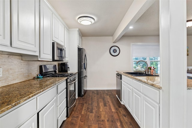 kitchen featuring a sink, stainless steel appliances, tasteful backsplash, and white cabinets