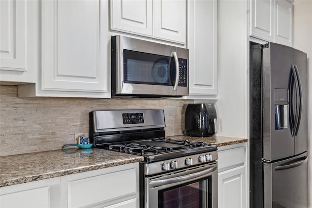 kitchen with stainless steel appliances, white cabinetry, and tasteful backsplash