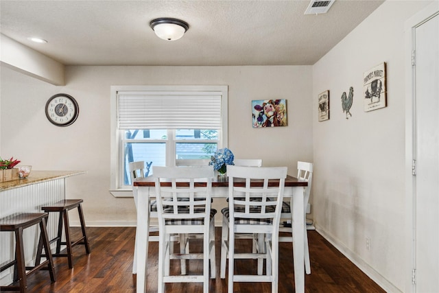 dining area featuring baseboards, visible vents, and dark wood-style floors
