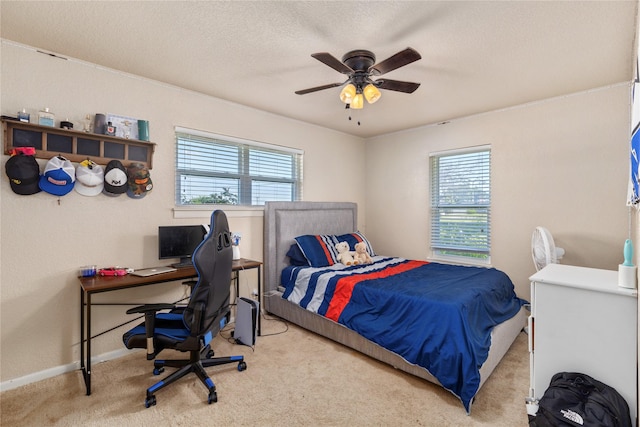 carpeted bedroom with a textured ceiling, baseboards, and ceiling fan