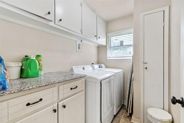 clothes washing area featuring separate washer and dryer, light tile patterned flooring, and cabinet space
