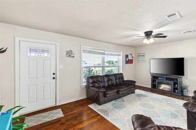 living area with ceiling fan, baseboards, visible vents, and wood finished floors