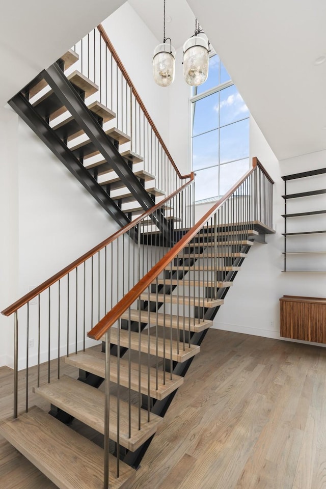 5747 Charlestown Dr, Dallas, TX 75230 - stairway featuring baseboards, a chandelier, a high ceiling, and wood finished floors
