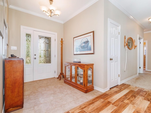 entrance foyer with ornamental molding, a chandelier, and baseboards