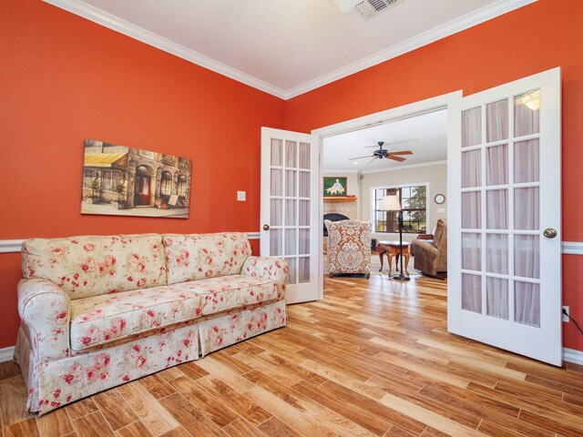 living area featuring ornamental molding, wood finished floors, french doors, and baseboards