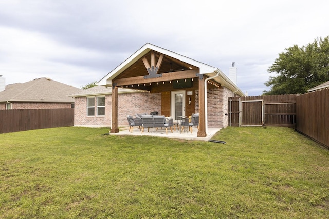 rear view of house featuring a chimney, a lawn, a fenced backyard, brick siding, and an outdoor living space