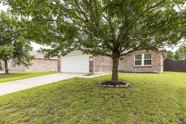 obstructed view of property featuring driveway, brick siding, fence, an attached garage, and a front lawn