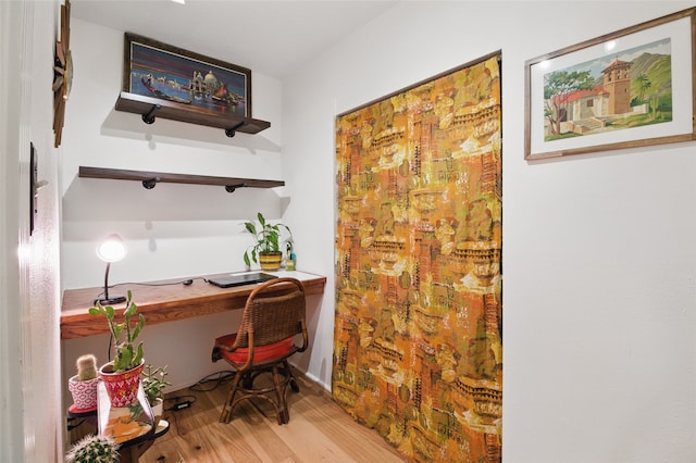 office space with built in study area and wood finished floors