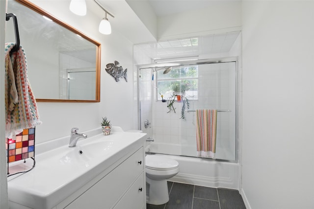 full bath with vanity, toilet, bath / shower combo with glass door, and tile patterned floors