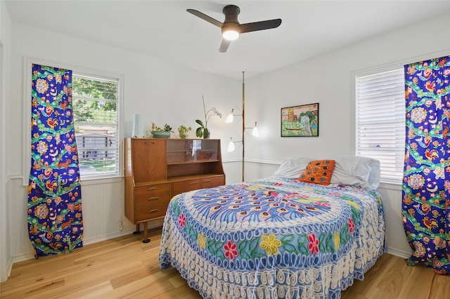 bedroom featuring light wood-style flooring, baseboards, and a ceiling fan